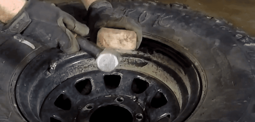 Man Hammering rim with wood block